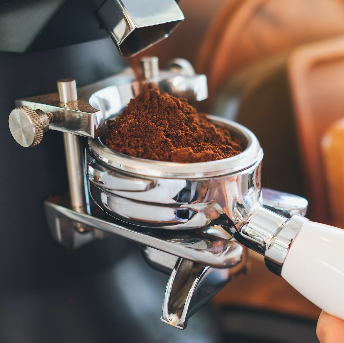Closeup image of barista grinding coffee in coffee shop